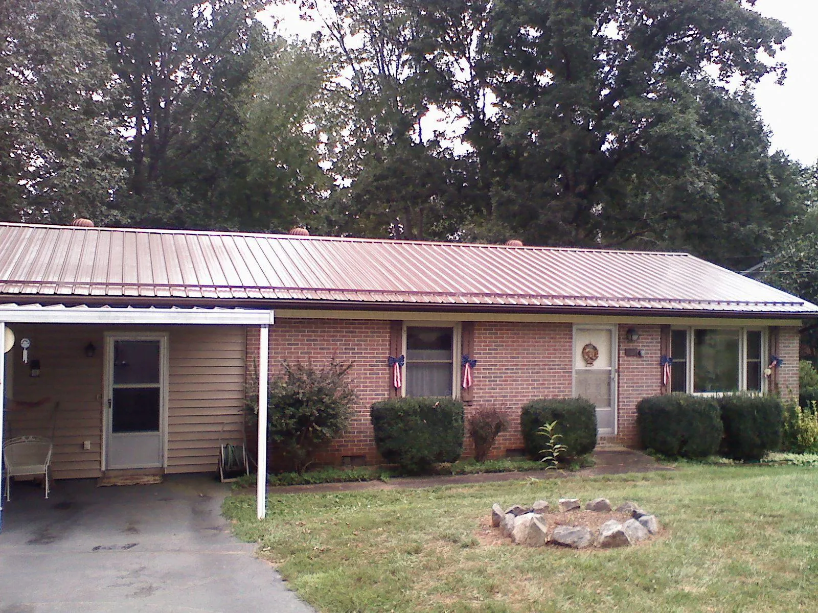Bronze metal roof and carport on a brick ranch home — Roof Repair work by our crew in New Paris